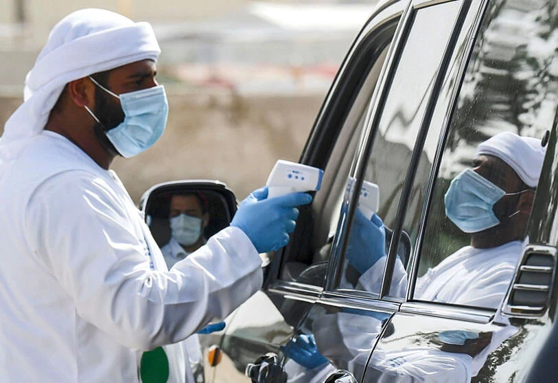 A health worker takes a driver’s body temperature inside a vehicle at a coronavirus testing center. (File/AFP)
