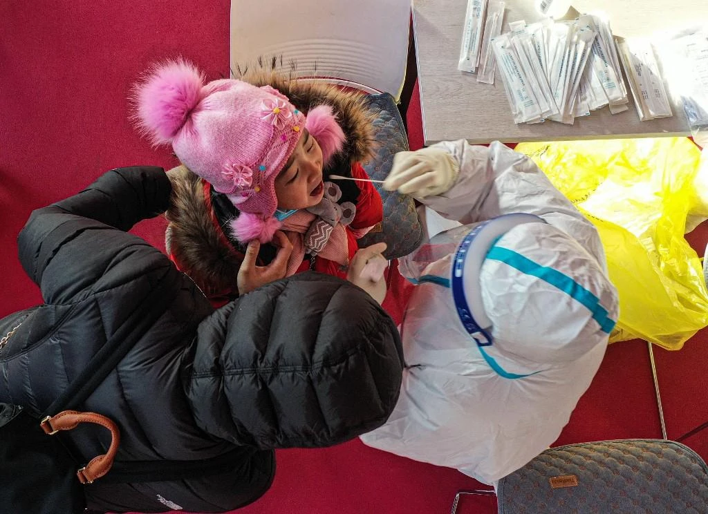 A health worker taking a swab sample from a child, to be tested for the COVID-19 coronavirus at a temporary testing centre in Shenyang, in China on Jan. 2, 2020. (File/AFP)