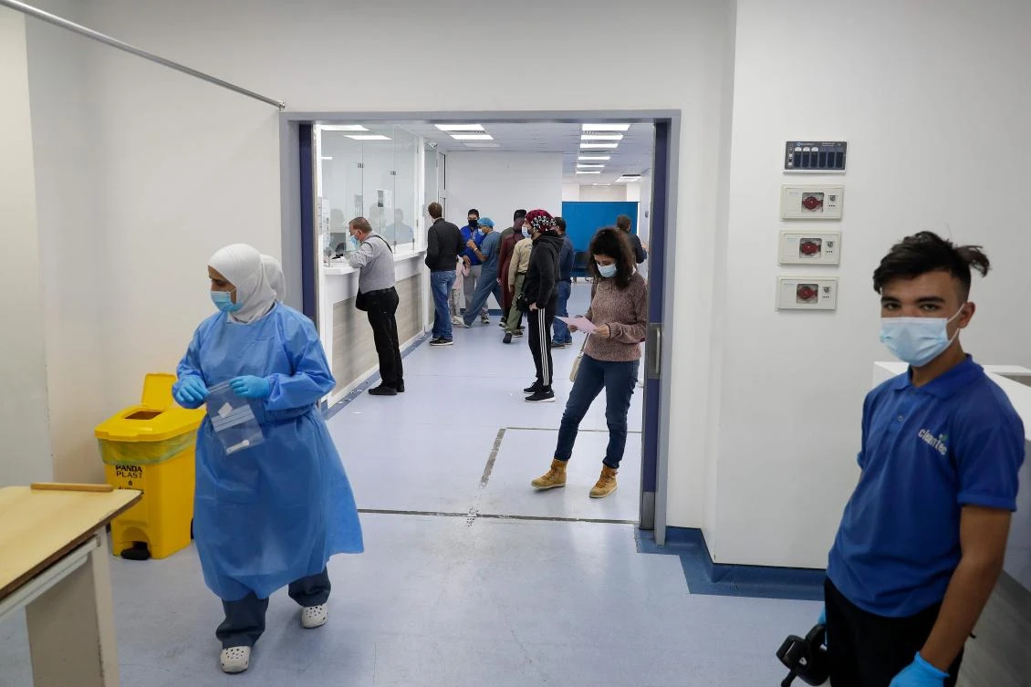 People queue for PCR tests in the intensive care unit of the Rafic Hariri University Hospital in the Lebanese capital Beirut, on January 5, 2021. (AFP)