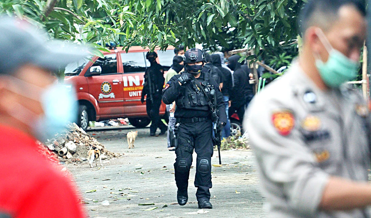 Police officers walk outside the site where two suspected militants were killed during a raid in Makassar, South Sulawesi, Indonesia, on Wednesday. (AP)