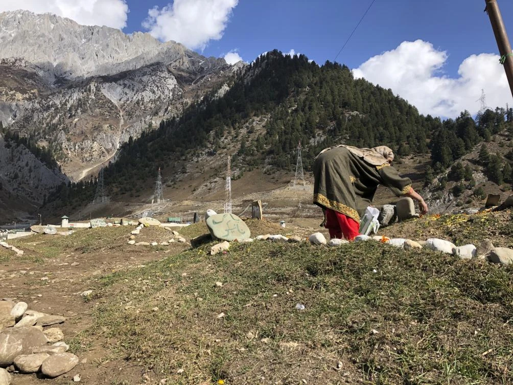 A woman offers flowers as relatives of suspected rebels killed by government forces visit a graveyard in Sonamarg in Indian controlled Kashmir on Nov. 3, 2020. (AP)