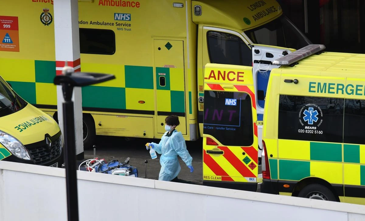 A healthcare worker wearing PPE cleans equipment after a patient arrived in an ambulance outside the Emergency Department of St Thomas' Hospital in London on January 3, 2021. (AFP)