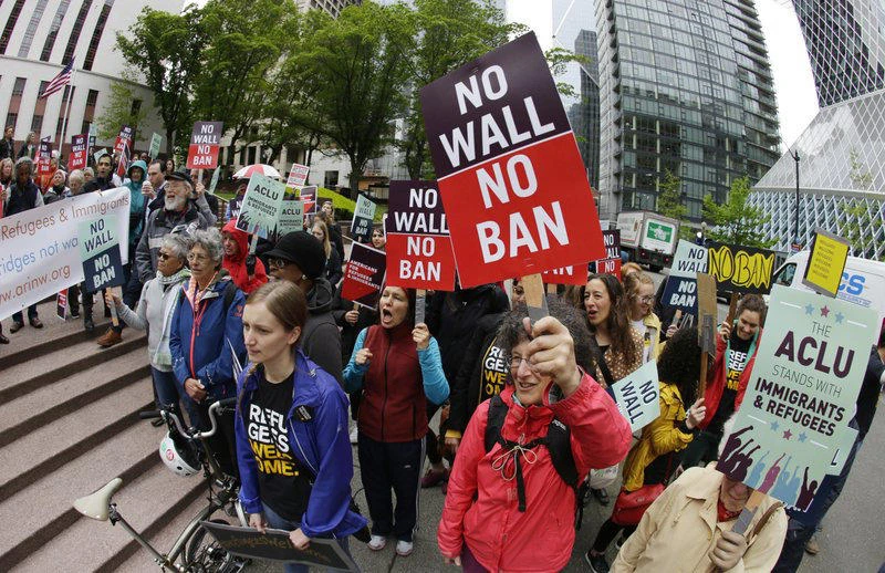 In this May 15, 2017 file photo, protesters wave signs and chant during a demonstration against President Donald Trump's revised travel ban outside a federal courthouse in Seattle. (AP Photo/Ted S. Warren, File)