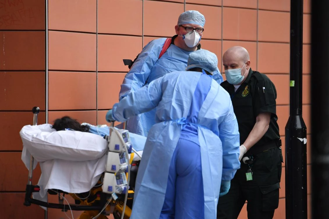 Paramedics unload a patient from an ambulance outside the Royal London Hospital in east London on January 8, 2021. (AFP)