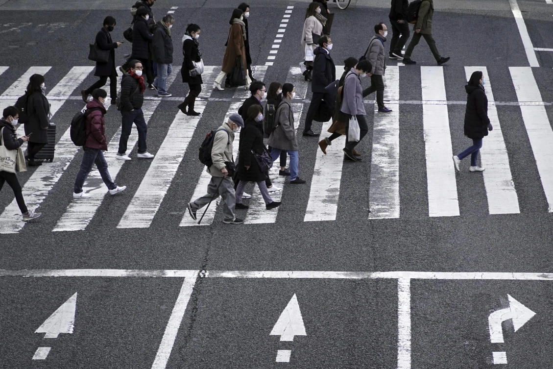 People wearing protective masks to help curb the spread of the coronavirus walk along pedestrian crossings in Tokyo Monday, Jan. 11, 2021. The Japanese capital confirmed more than 1200 new coronavirus cases on Monday. Japanese Prime Minister Yoshihide Suga declared a state of emergency last Thursday for Tokyo and three other prefectures to ramp up defenses against the spread of the coronavirus. (AP)