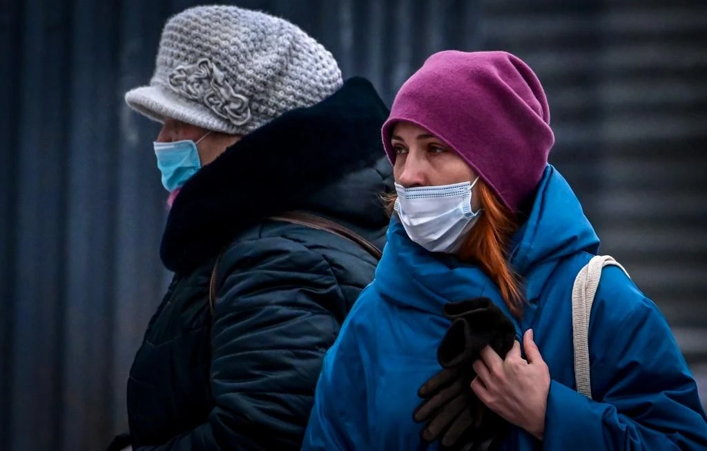 Two women wearing face masks to protect against the coronavirus disease walk along a street in central Moscow on Jan. 9, 2021. (File/AFP)