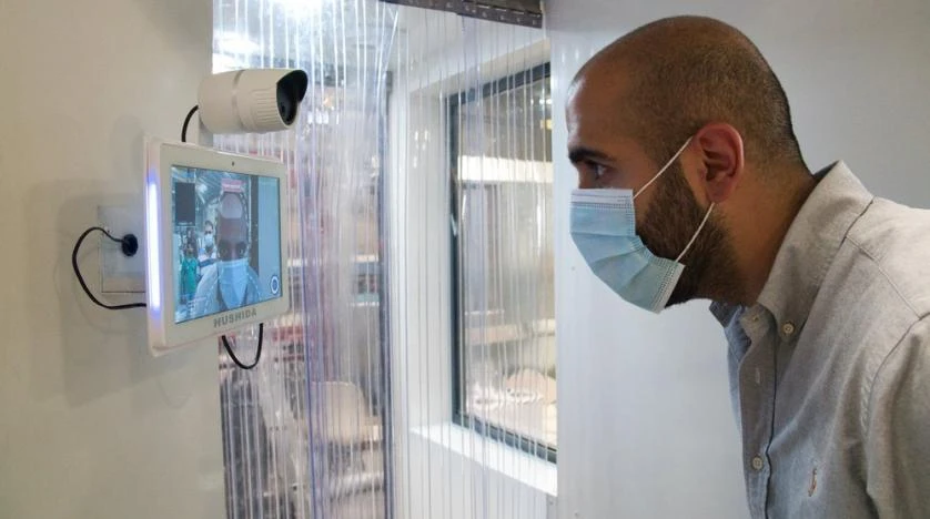A worker examines a gate system made by Guard ME that conducts temperature checks and fogs disinfectants on users, in Dubai, UAE. (File/AP)