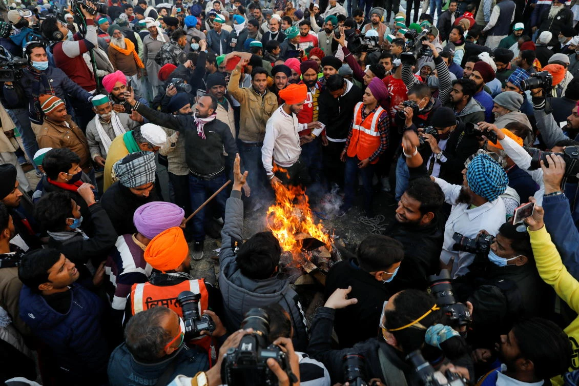 Farmers burn farm law copies as they celebrate the Lohri festival at the Delhi-Uttar Pradesh border in Ghaziabad, India January 13, 2021. (Reuters)