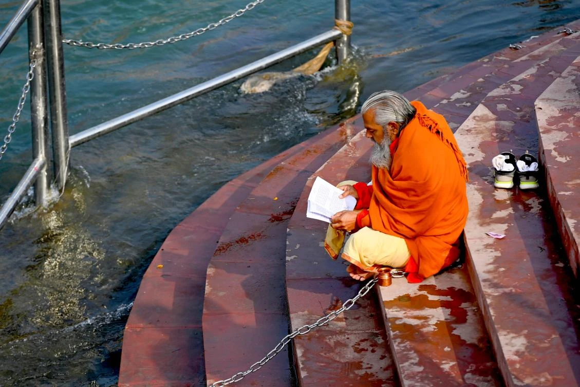 A Hindu holyman reads at a ghat of the River Ganges ahead of their religious Kumbh Mela festival in Haridwar on January 13, 2021. (AFP)