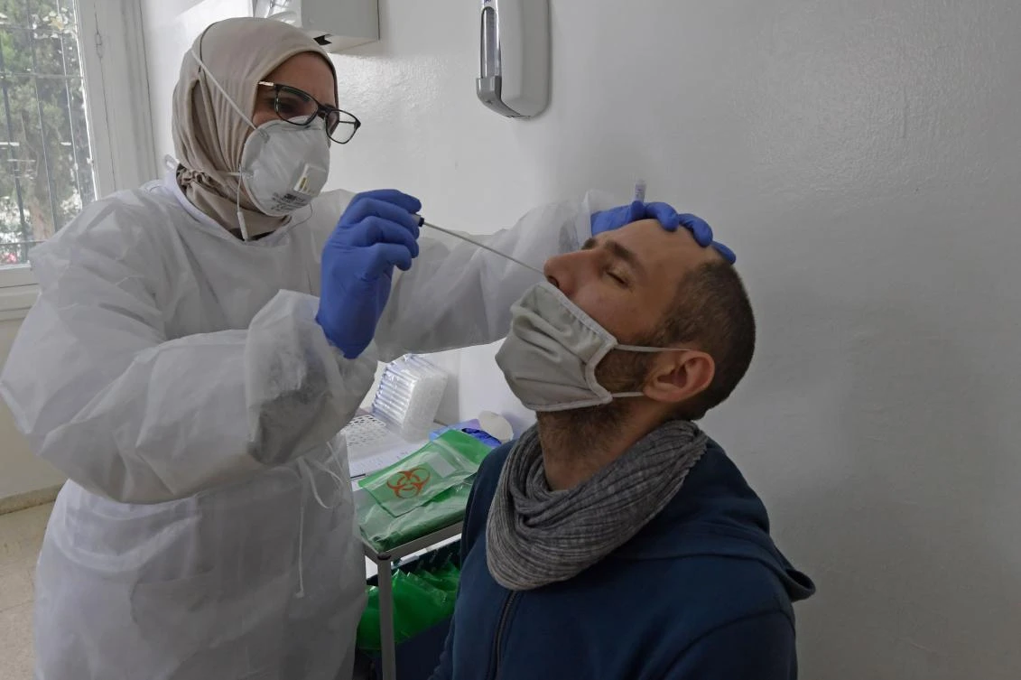 A lab technician takes a swab sample from a man for the COVID-19 test at the Pasteur Institute in Tunis on January 13, 2021. (AFP)