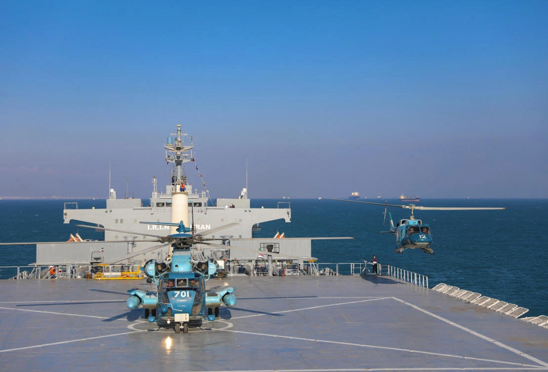 This image released Thursday, Jan. 14, 2021, by the Iranian Army shows helicopters and the Iranian-made Makran logistics vessel during a naval drill. Iran fired cruise missiles Thursday as part of the drill in the Gulf of Oman, state media reported. (Iranian Army via AP)