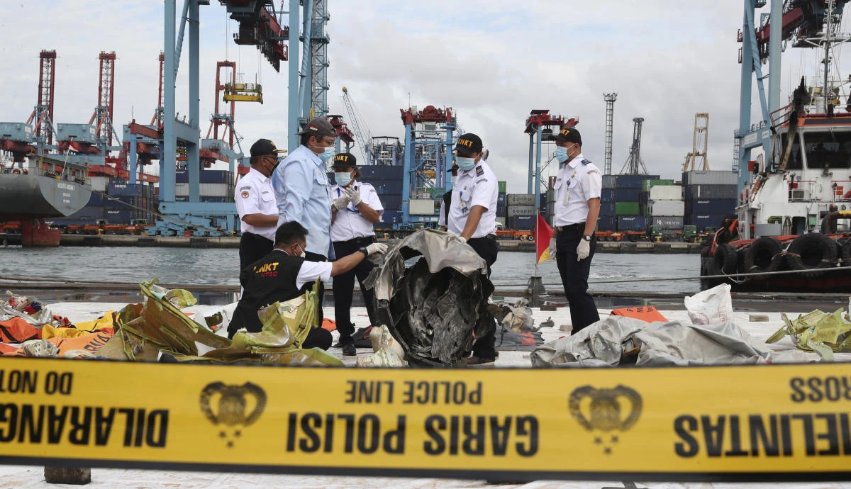Indonesian National Transportation Safety Committee investigators inspect debris found in the waters around the location where Sriwijaya Air passenger jet crashed on Jan. 13, 2021, in Jakarta. (AP)