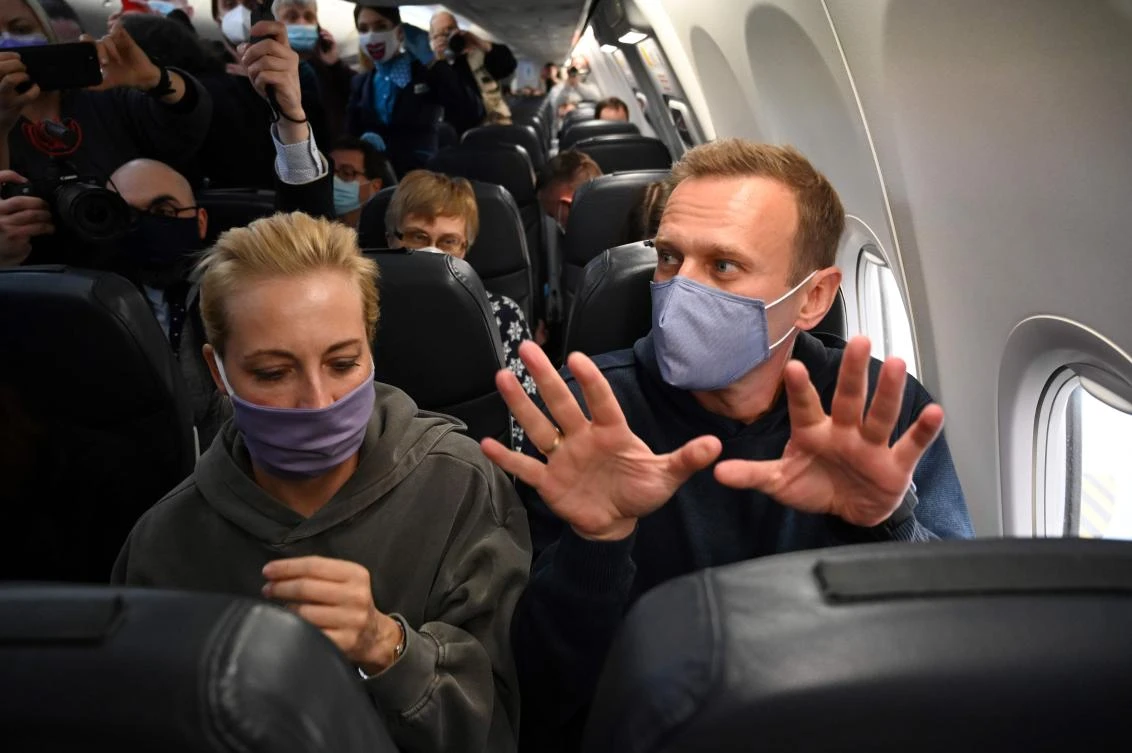 Russian opposition leader Alexei Navalny gestures sitting next to his wife Yulia in a Pobeda airlines plane heading to Moscow before take-off from Berlin Brandenburg Airport (BER) in Schoenefeld, southeast of Berlin, on January 17, 2021. (AFP)