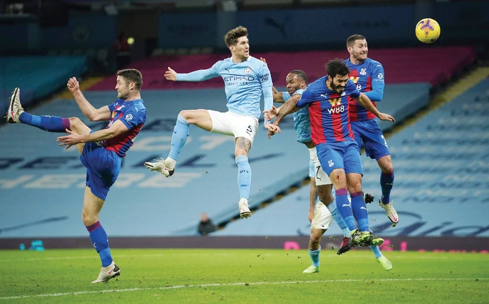 Manchester City’s English defender John Stones, center, jumps to head the ball to score the opening goal during Sunday’s football match in Manchester. (AFP)