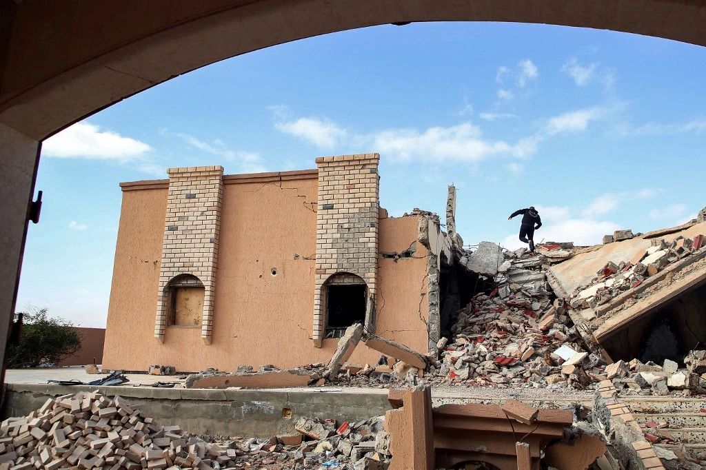 A youth climbs the rubble of a destroyed building in the city of Tawergha, near Misrata. (AFP/File)