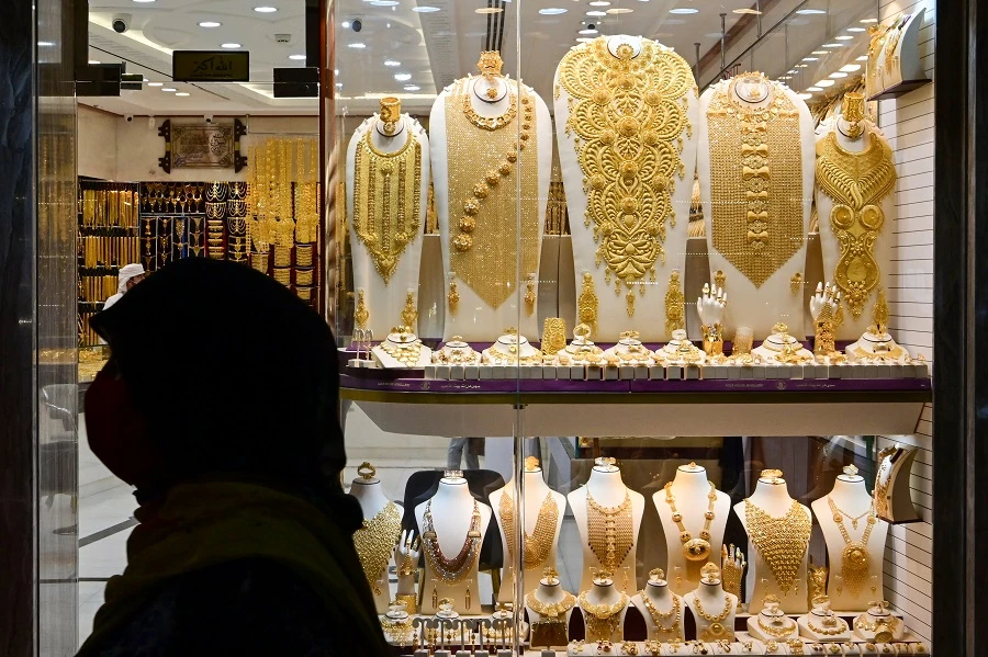 A woman walks past a gold merchant in Dubai Gold Souk in the Gulf emirate on July 29, 2020. (File/AFP)