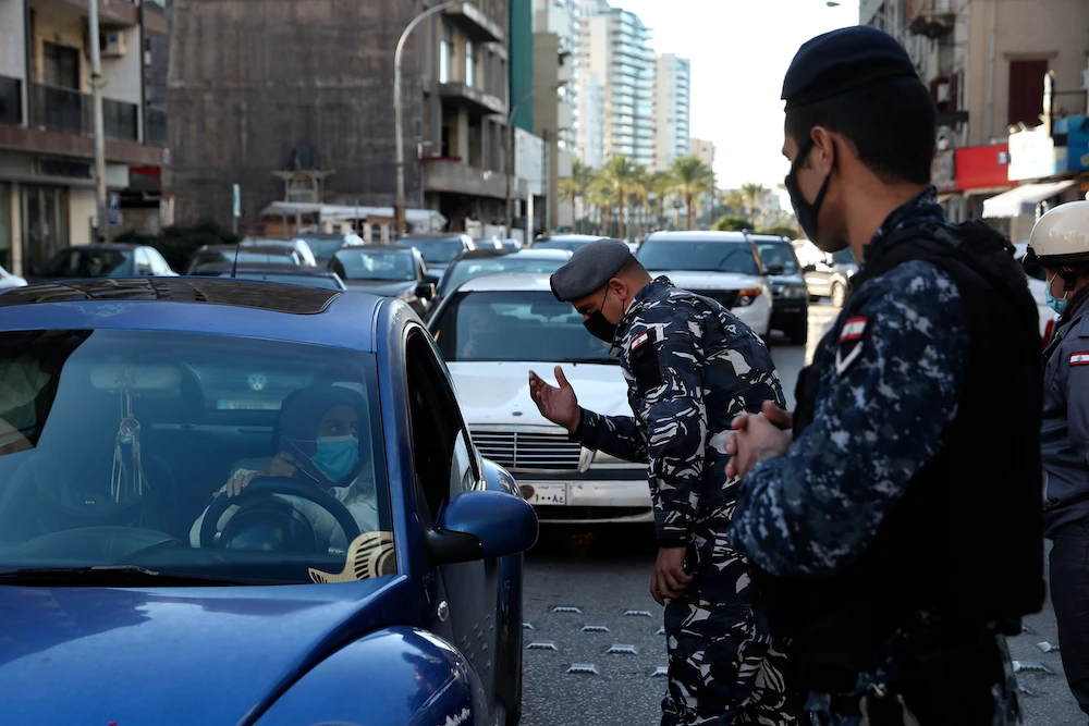 Police officers speak to a driver at a checkpoint while inspecting cars for violating a lockdown to help prevent the spread of the coronavirus, in Beirut Lebanon, Thursday, Jan. 21, 2021. (AP)