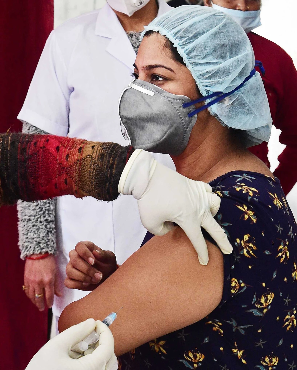 A medical worker inoculates a colleague with a COVID-19 coronavirus vaccine at the north central railway hospital in Allahabad on Friday. (AFP)
