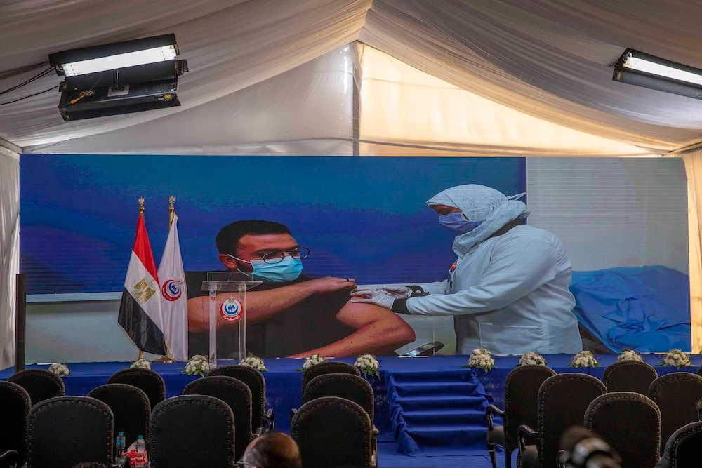 Dr. Abdel Menoim Selim, is shown on a live screen receiving the Sinopharm COVID-19 vaccine, ahead of a press conference, at the Abu Khalifa Hospital in Ismailia, 120 kilometers (75 miles) east of Cairo, Egypt, Sunday, Jan. 24, 2021. (AP)