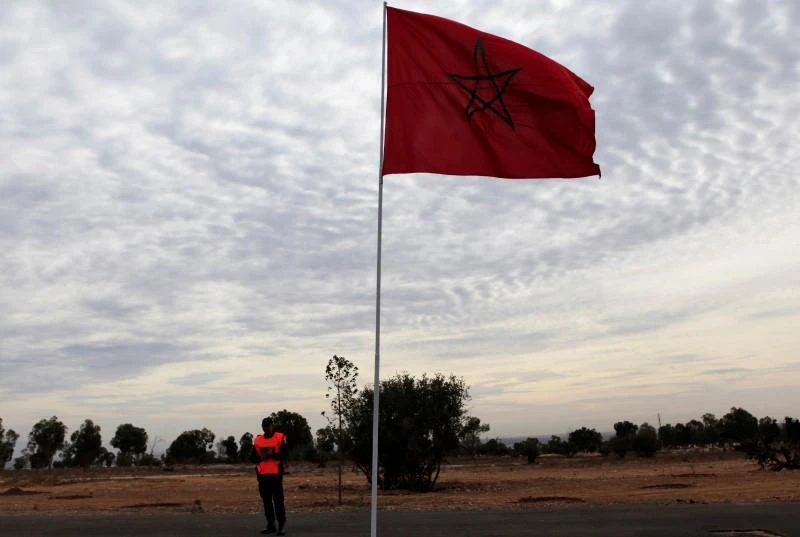 File photo of a police officer standing near a Moroccan national flag in Agadir, December 10, 2013. (Reuters)