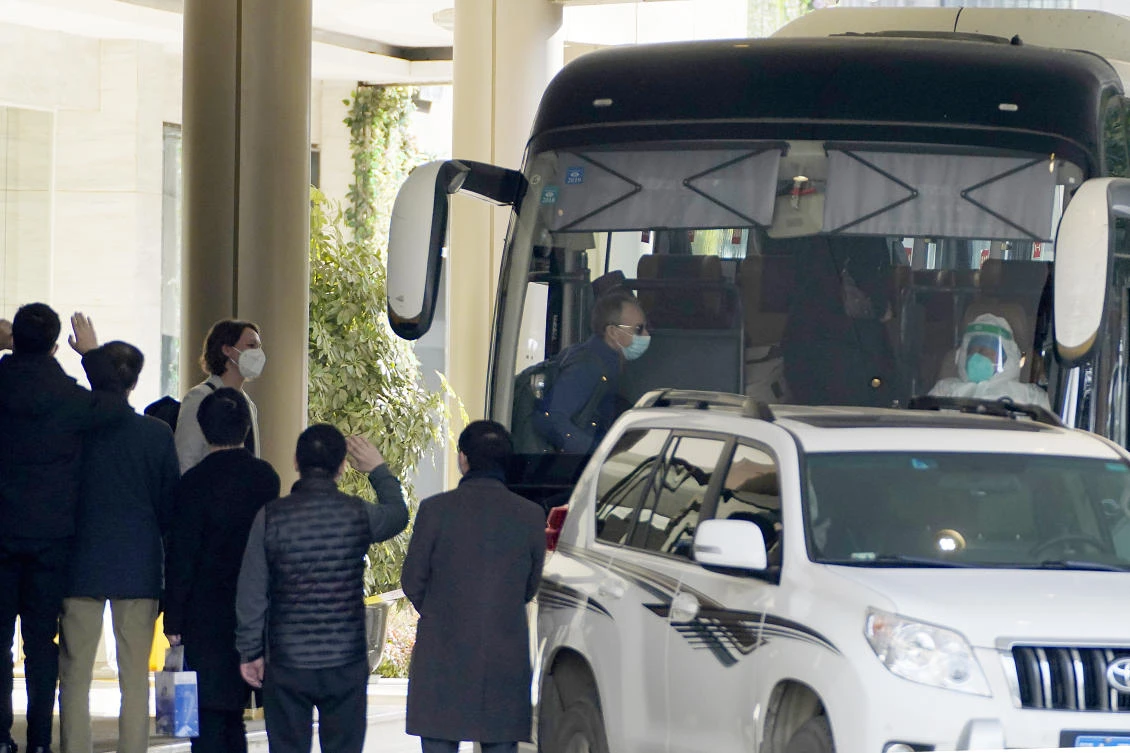 Workers wave to the team of experts from the World Health Organization who ended their quarantine and prepare to leave the quarantine hotel by bus in Wuhan in central China's Hubei province on Thursday, Jan. 28, 2021. (AP)