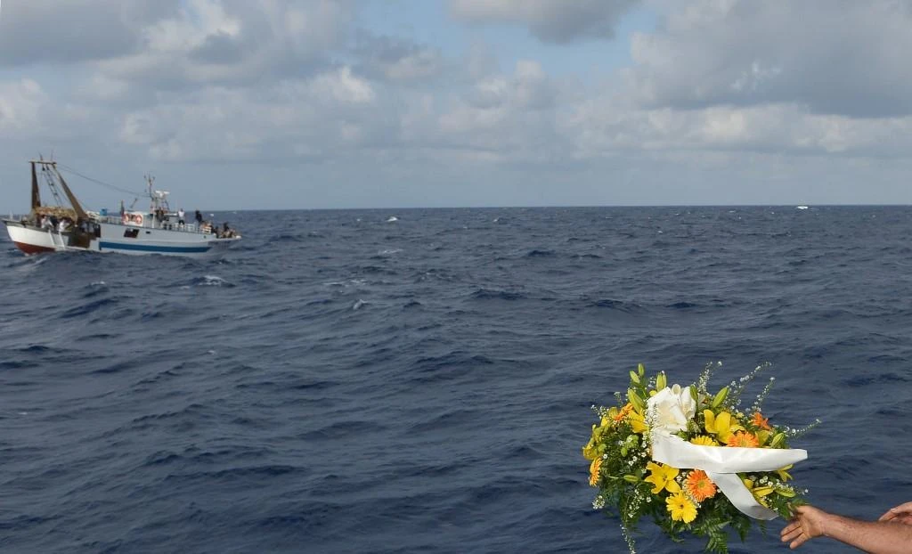 Fishermen throw a bunch of flowers in the sea near the Lampedusa harbor on October 2013 after a boat with migrants sank killing more than a hundred of people. (AFP file photo)