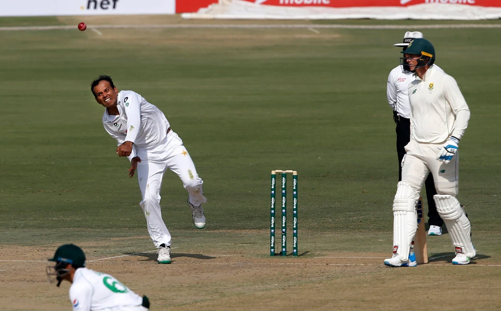 Pakistan's spinner Nauman Ali, left, bowls during the first day of the first cricket test match between Pakistan and South Africa at the National Stadium in Karachi, Pakistan, on Jan. 26, 2021.(AP Photo/Anjum Naveed)