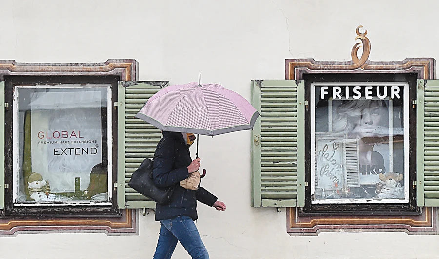 A woman walks past shop windows of a closed hairdresser in Garmisch-Partenkirchen, southern Germany, amid the ongoing novel coronavirus pandemic. (File/AFP)