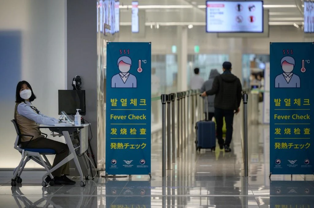 A health worker waits to screen passengers at Incheon international airport on Dec. 29, 2020, amid the COVID-19 coronavirus pandemic. (File/AFP)