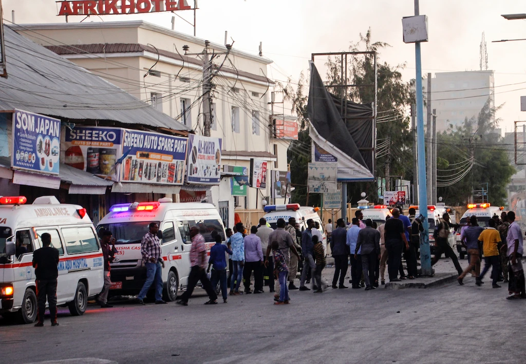 Ambulances and security forces gather on the street outside the Afrik hotel in the capital Mogadishu, Somalia Sunday, Jan. 31, 2021. The hotel in Somalia's capital has been hit by an explosion and an attack by gunmen, according to police. (AP)