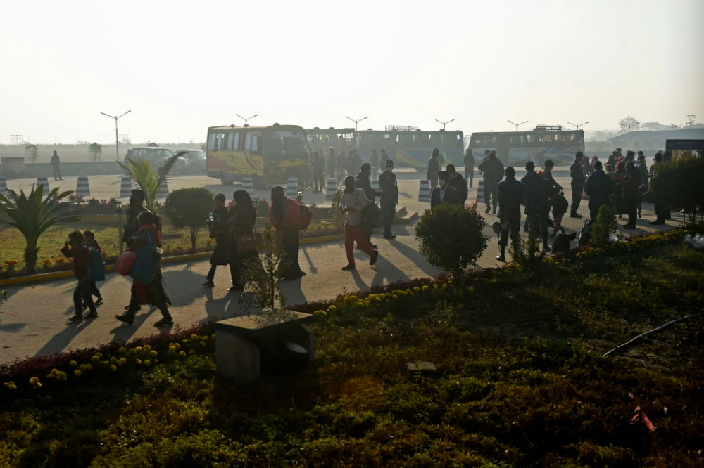 Rohingya refugees walk with their belongings to board a Bangladesh Navy ship in Chittagong on January 29, 2021 as they are being relocated to Bhashan Char Island in the Bay of Bengal. (AFP / Munir Uz zaman)