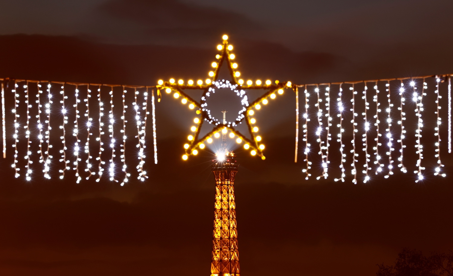 An illuminated star shines in a Paris street with the Eiffel Tower in the background on January 1, 2021. (Reuters)