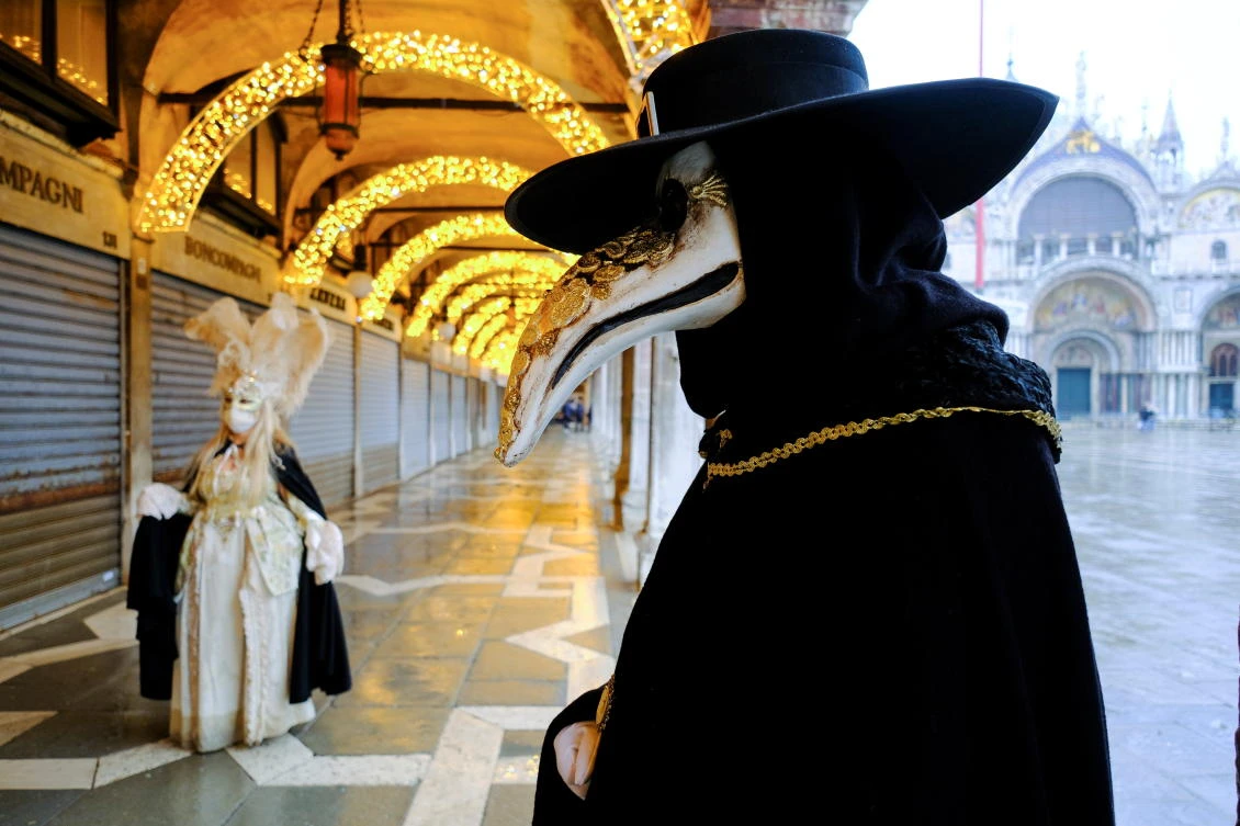 People wear carnival masks and costumes in St. Mark's Square to celebrate Venice's annual colourful carnival, which has been cancelled this year due to the coronavirus disease (COVID-19) pandemic, in Venice, Italy, February 7, 2021. REUTERS/Manuel Silvestri