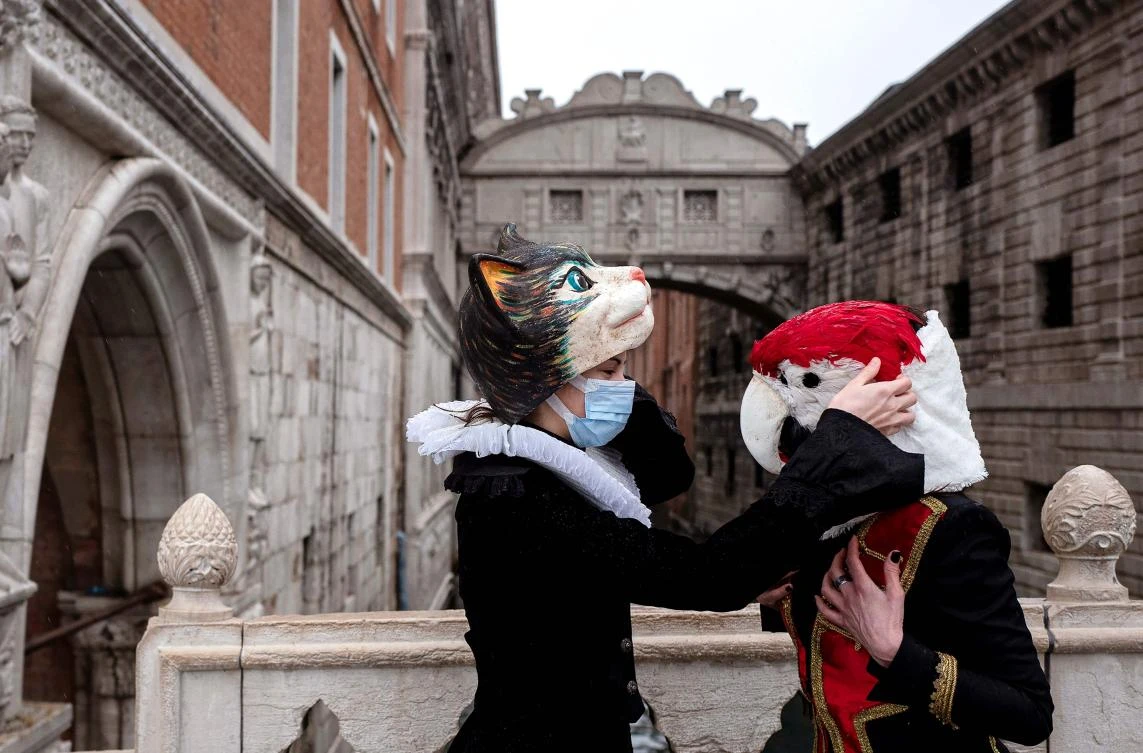 Venetians artisans set their carnival mask and costumes by the Bridge of Sighs (Ponte dei Sospiri) after a demonstration of The Confederation of Venice Artisans (Confartigianato Venezia) at St. Mark's square in Venice on February 7, 2021, as the carnival is being cancelled due to the Covid-19 pandemic. / AFP / Marco Bertorello