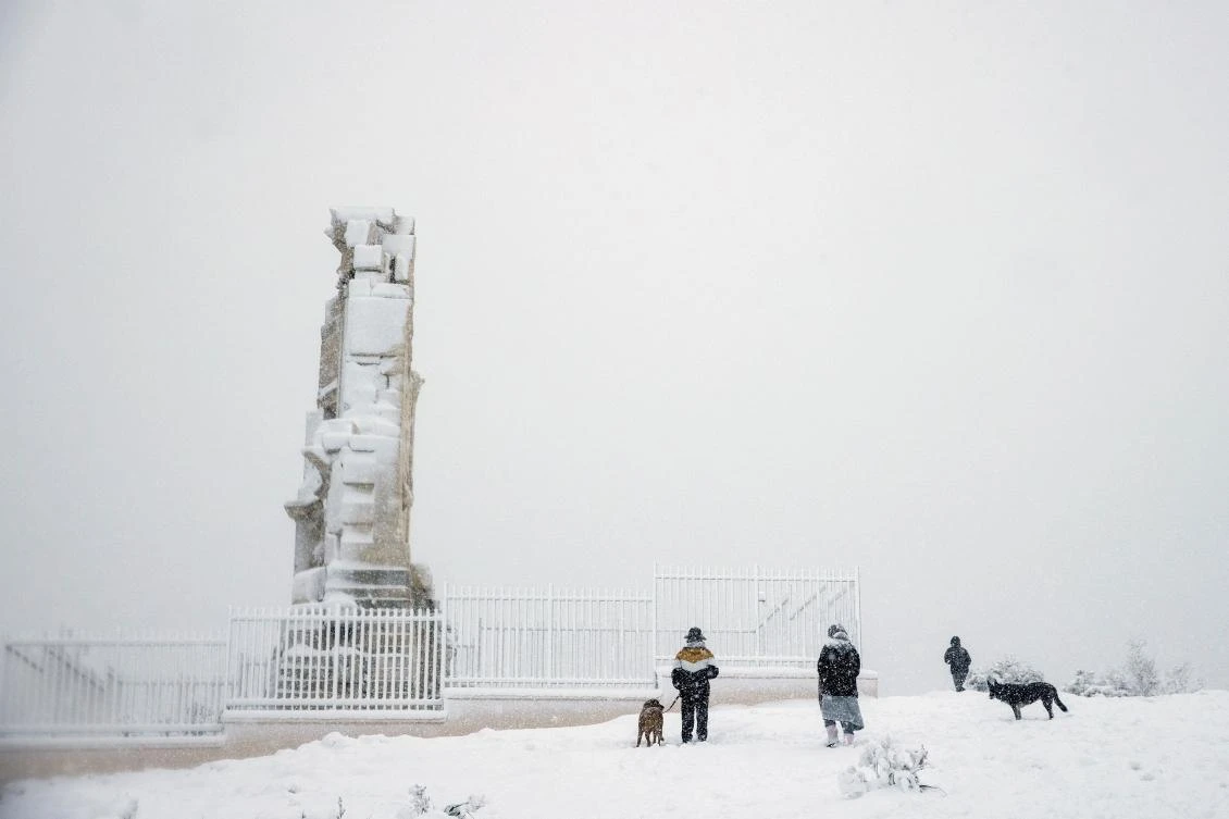 People make their way atop the Filopappou hill during a heavy snowfall in Athens, Greece, February 16, 2021. REUTERS/Alkis Konstantinidis