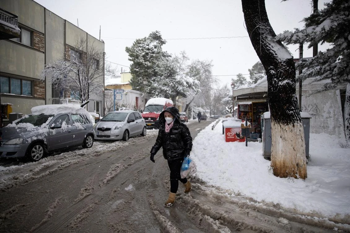 A woman wearing a protective face mask makes her away after heavy snowfall, in the village of Krioneri, Greece, February 15, 2021. REUTERS/Alkis Konstantinidis