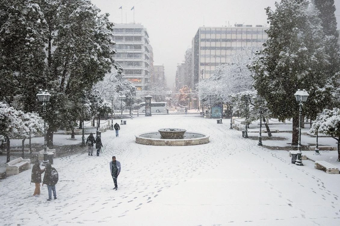 People make their way on Syntagma square during heavy snowfall in Athens, Greece, February 16, 2021. REUTERS/Alkis Konstantinidis