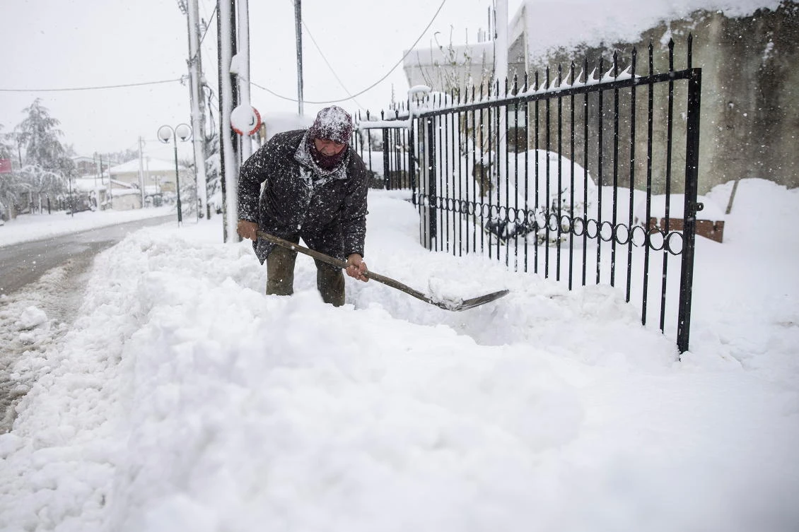 Panagiotis Economou shovels snow from the entrance of his property during heavy snowfall, in the village of Kapandriti, Greece, February 15, 2021. REUTERS/Alkis Konstantinidis