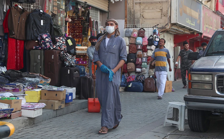 A mask-clad man walks past shops in Saudi Arabia's holy city of Mecca on May 31, 2020 as lockdown measures are eased amid the COVID-19 pandemic. (AFP/File)
