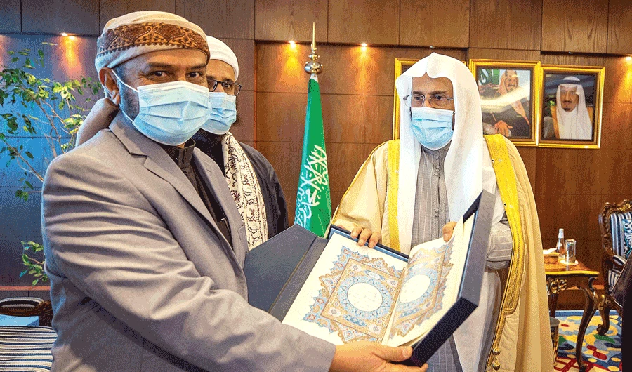 Saudi Islamic Affairs Minister Sheikh Abdullatif Al-Asheikh presents a copy of the Holy Qur’an to Yemeni officials at his office in Riyadh on Monday. (SPA)