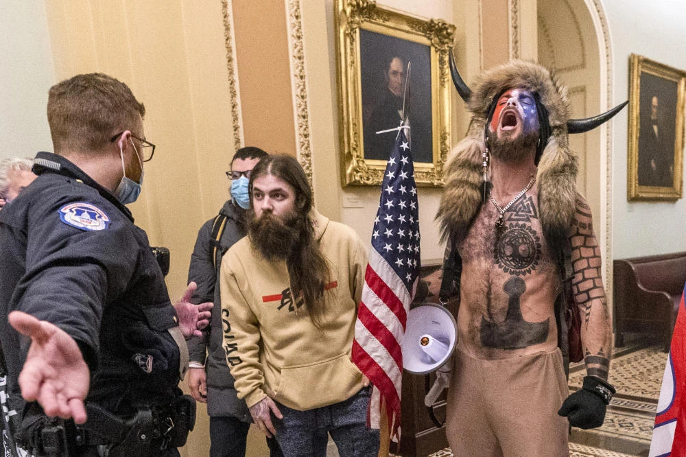 In this Jan. 6, 2021 file photo, supporters of President Donald Trump, including Jacob Chansley, with horns, are confronted by US Capitol Police officers outside the Senate Chamber inside the Capitol in Washington. (AP Photo/Manuel Balce Ceneta, File)