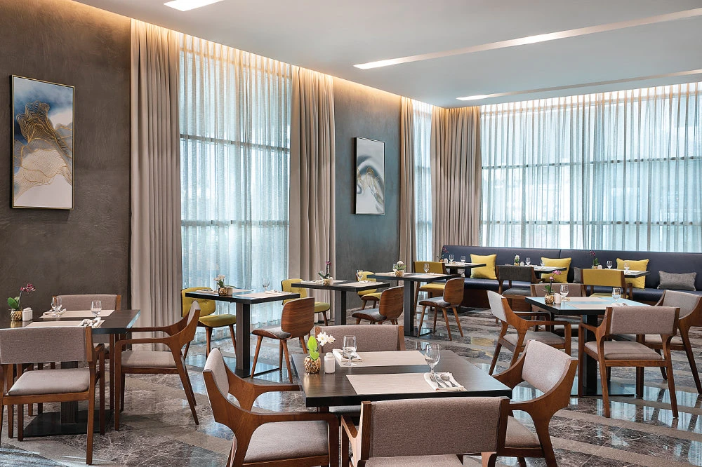 The venue’s striking décor, an open kitchen and a live cooking station take center stage, ensuring guests seated indoors get to immerse themselves in the culinary show.