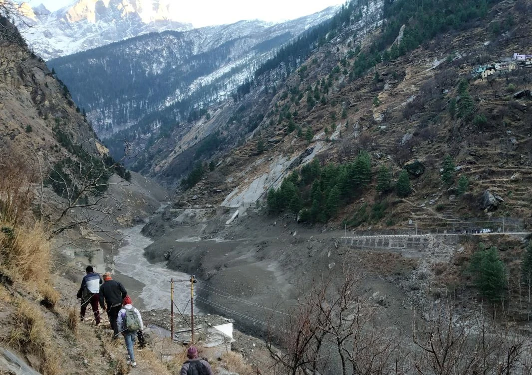 People walk past a destroyed dam after a Himalayan glacier broke and crashed into the dam at Raini Chak Lata village in Chamoli district, northern state of Uttarakhand, India, February 7, 2021. (Reuters)