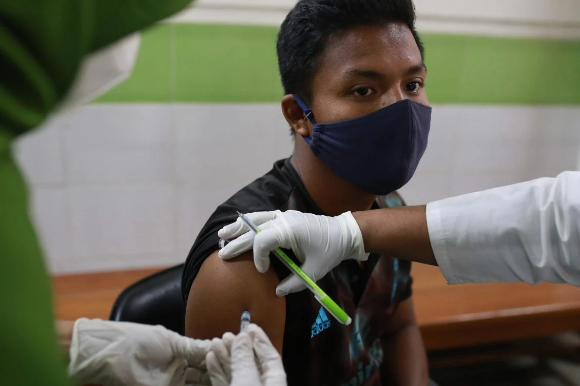 A medical staff inoculates a man with a Covid-19 coronavirus vaccine at the Mugda General Hospital as the vaccination began across the country, in Dhaka on February 7, 2021. (AFP)