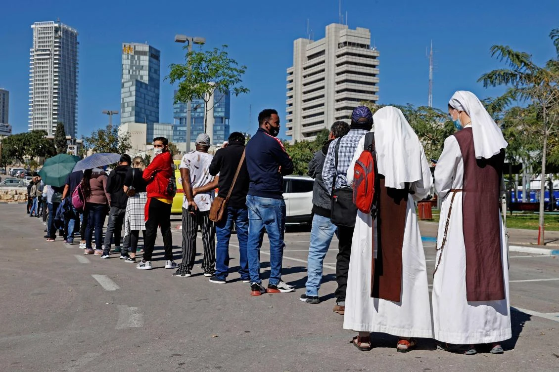 Above, French nuns living in Israel queue with other foreign residents to receive a dose of coronavirus vaccine at the Tel Aviv Sourasky Medical Center on Feb. 9, 2021. (AFP)