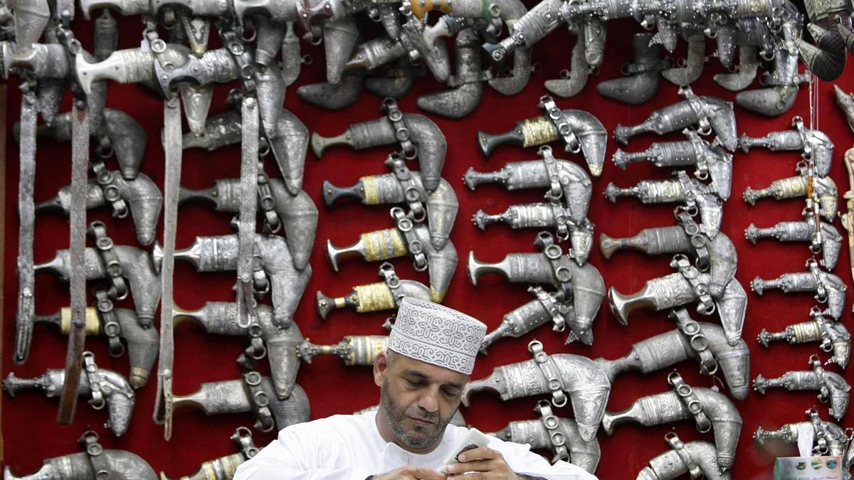An Omani sits in front of a display of khanjars (traditional daggers) in Muttrah Souq, the oldest market in Oman, in the capital, Muscat. (Reuters)