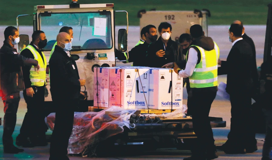 Workers unload the first shipment of the Pfizer-BioNTech vaccine for COVID-19 on Saturday at the Rafic Hariri International Airport in Beirut, Lebanon. (AP)