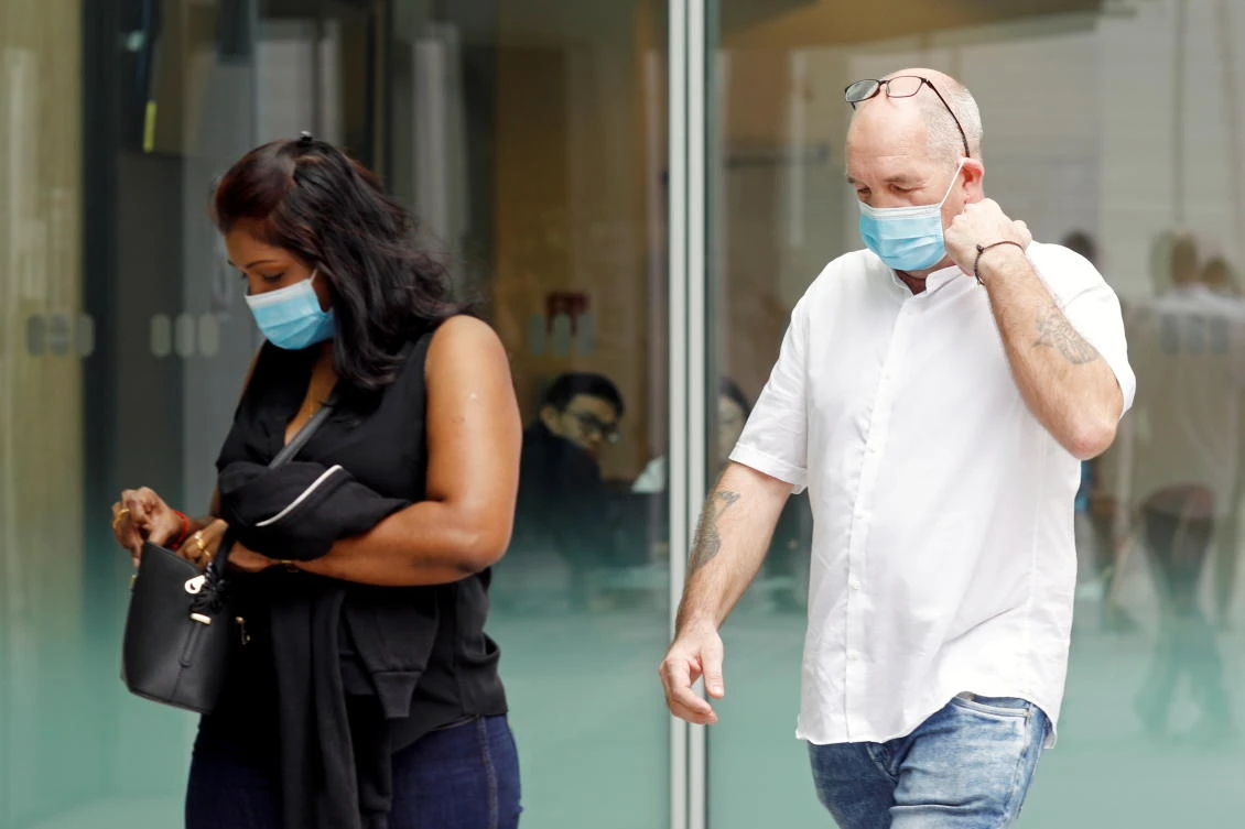 Briton Skea Nigel, left, and partner Agatha Maghesh Eyamalai arrive at the State Courts for a hearing after breaking coronavirus disease quarantine regulations on Feb. 15, 2021. (Reuters)