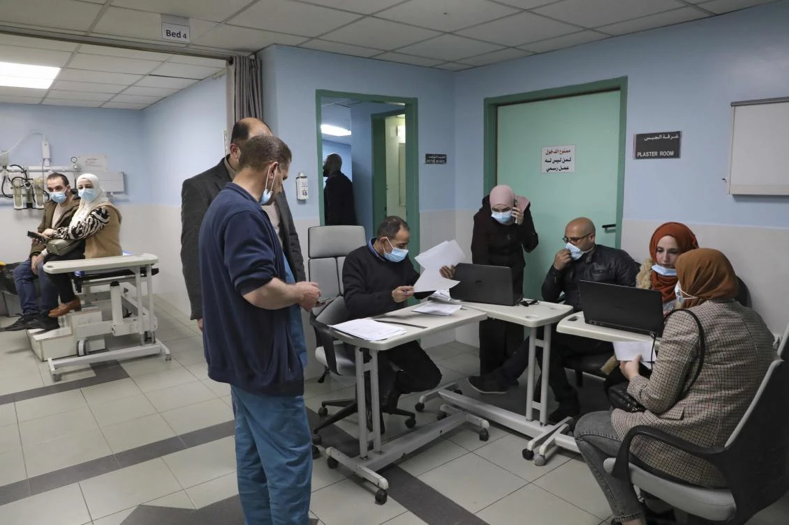 Palestinian register for the COVID vaccine at the Al-Mezan Hospital in Hebron city, in the occupied West Bank on February 14, 2021. (AFP)