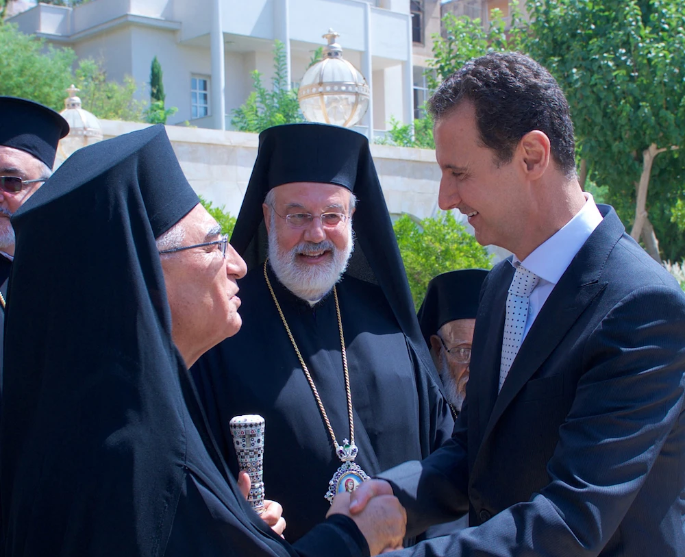 Syrian President Bashar Assad (R) meeting the new Melkite Greek Catholic Patriarch Youssef Absi (L) in the Syrian capital Damascus. (AFP/SANA/File Photo)